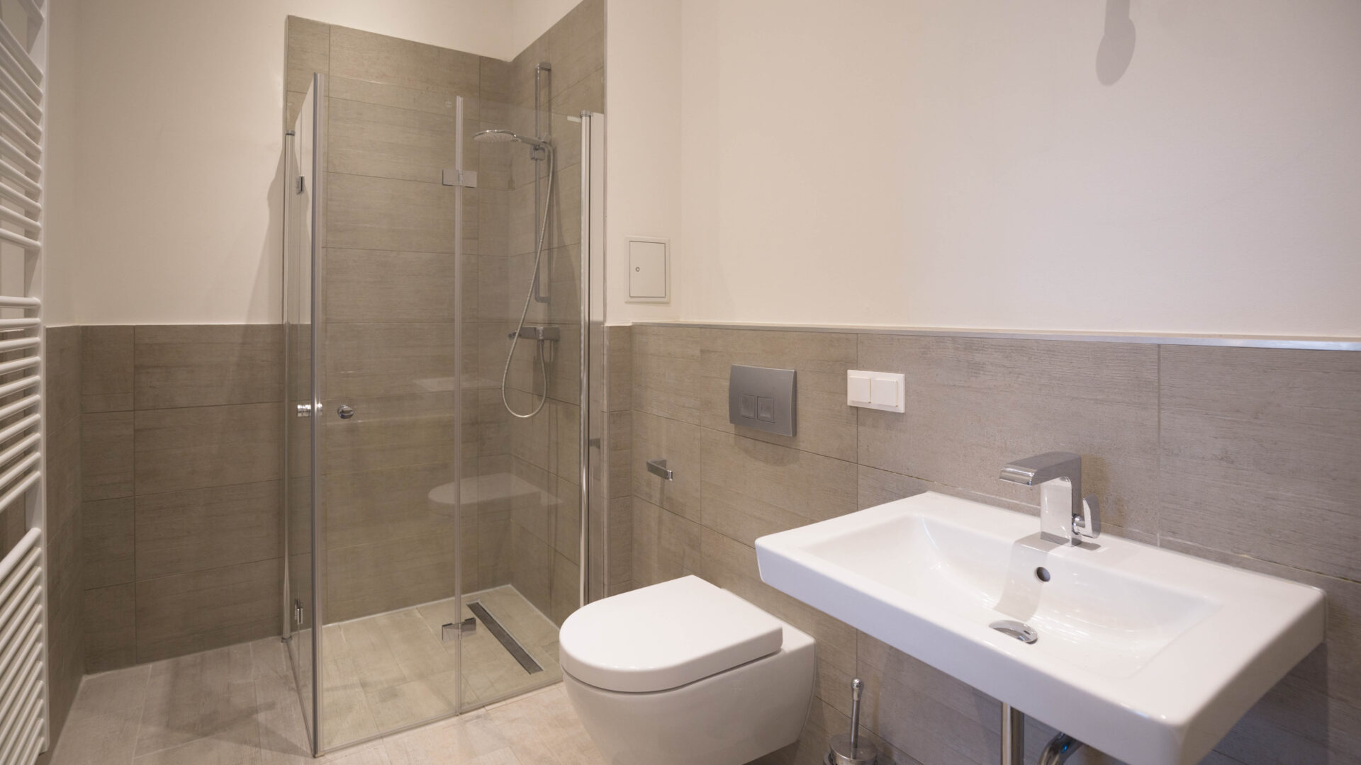 Modernes Badezimmer mit verglaster Duschkabine, WC und eckigem weißen Waschtisch